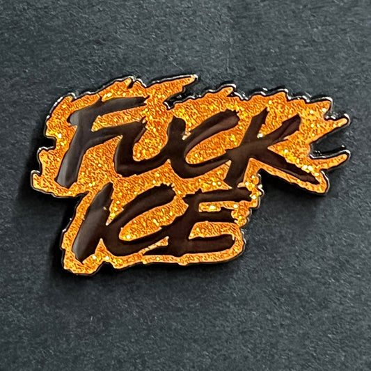 Orange and black 'F**K ICE' enamel pin on a dark background